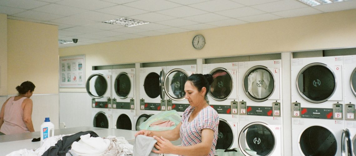 photo-of-woman-standing-inside-the-laundromat-2927523